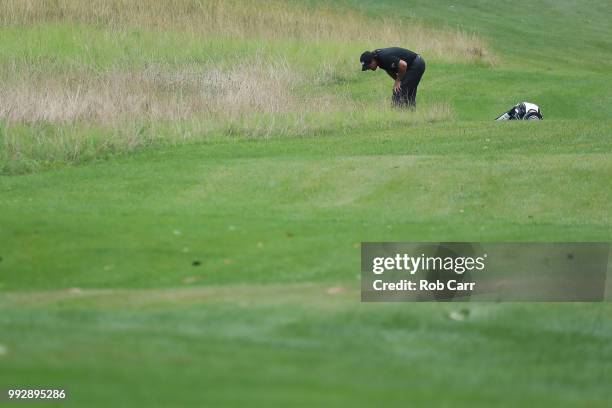 Phil Mickelson searches for his ball on the 14th hole during round two of A Military Tribute At The Greenbrier held at the Old White TPC course on...