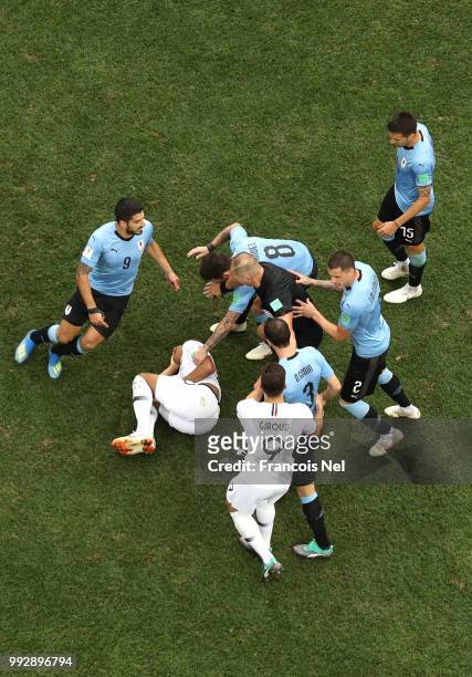 Kylian Mbappe of France lies on the pitch injured while Uruguay and France players argue during the 2018 FIFA World Cup Russia Quarter Final match...