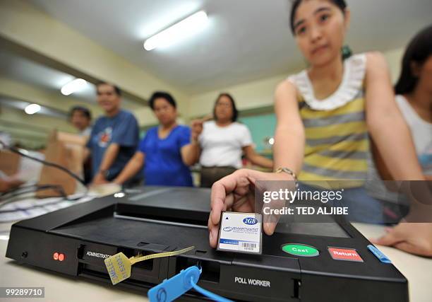 In this file photo taken on May 6, 2010 an election official holds a newly configured memory card during a test of a vote counting machine at a...