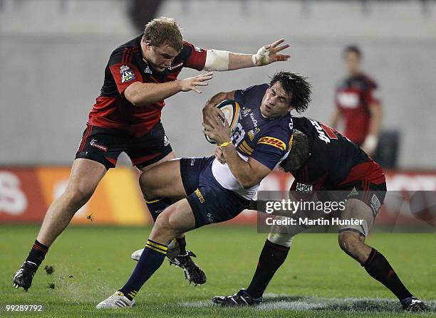 George Smith of the Brumbies is tackled by Owen Franks and Richie McCaw of the Crusaders during the round 14 Super 14 match between the Crusaders and...