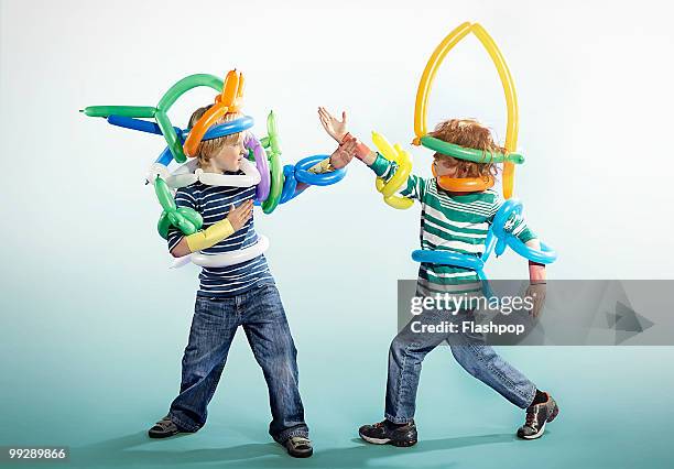 portrait of two boys playing in fancy dress - child balloon studio photos et images de collection