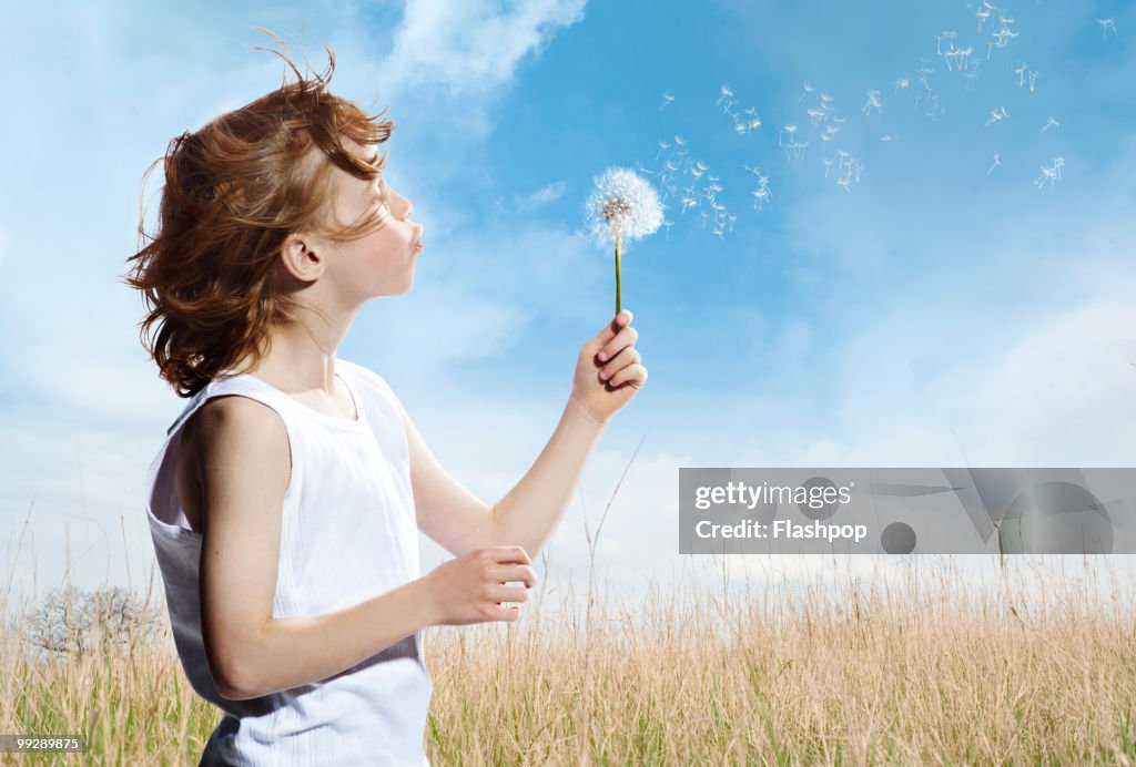 Portrait of boy blowing dandelion clock