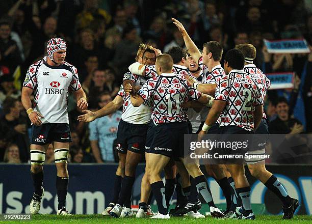 Kurtley Beale of the Waratahs is congratulated by team mates after scoring a try during the round 14 Super 14 match between the Waratahs and the...