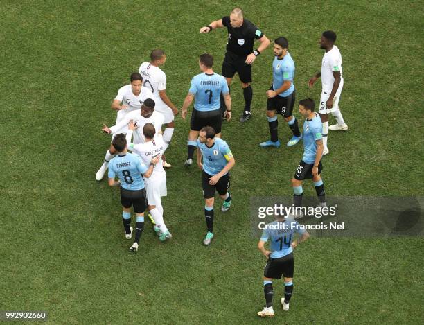 Referee Nestor Pitana talks to Uruguay and France players as Paul Pogba of France is held back as tempers flare during the 2018 FIFA World Cup Russia...