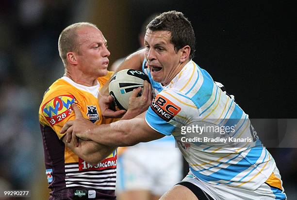 Greg Bird of the Titans takes on the defence of Darren Lockyer of the Broncos during the round 10 NRL match between the Brisbane Broncos and the Gold...