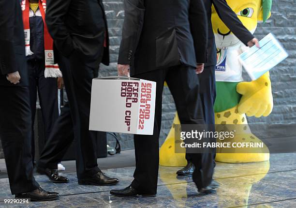 Members of the delegation holds the England 2018 and 2022 World Cup bid books close to "Zakumi" the FIFA 2010 World Cup mascot prior to an official...