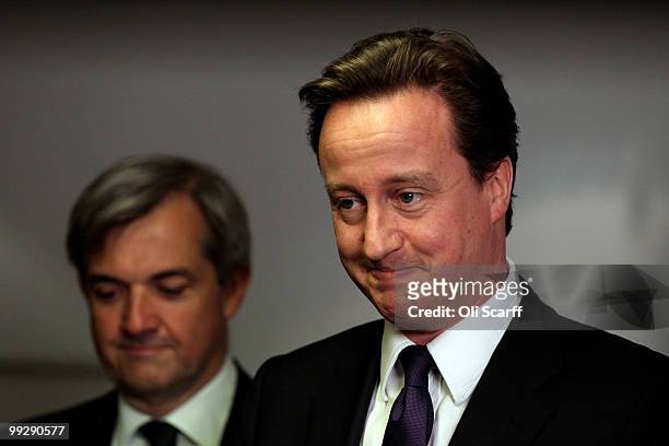 British Prime Minister David Cameron speaks next to Chris Huhne, the Secretary of State for Energy and Climate Change, during address to Department...