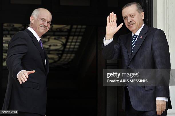 Greek Premier George Papandreou and his Turkish counterpart Recep Tayyip Erdogan wave towards photographers before their meeting in Athens on May 14,...