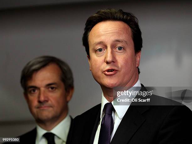 British Prime Minister David Cameron speaks next to Chris Huhne, the Secretary of State for Energy and Climate Change, during address to Department...