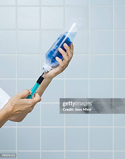 nurse injecting adjuvant in iv drip - newhealth stock pictures, royalty-free photos & images