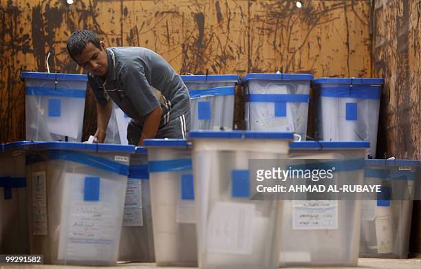 Worker with the Independent High Electoral Commission loads ballot boxes into the back of a truck to transport them for storage after finishing the...