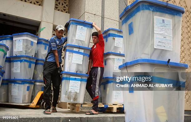Workers with the Independent High Electoral Commission load ballot boxes into the back of a truck to transport them for storage after finishing the...