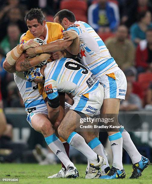 Corey Parker of the Broncos is wrapped up by the Titans defence during the round 10 NRL match between the Brisbane Broncos and the Gold Coast Titans...