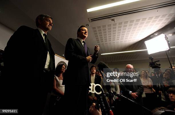 British Prime Minister David Cameron speaks next to Chris Huhne, the Secretary of State for Energy and Climate Change, during address to Department...