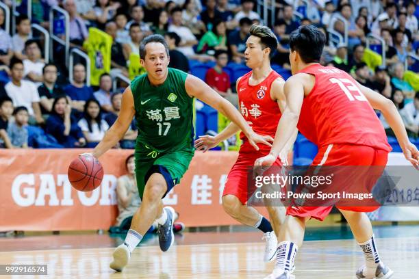 Chow Ka Kui of Tycoon Basketball Team dribbles the ball up court against the SCAA during the Hong Kong Basketball League playoff game between SCAA...