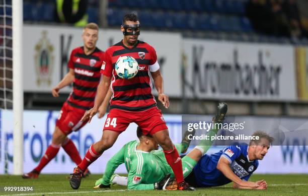 Bielefeld's Soeren Brandy lies on the pitch while Marvin Matip of Ingolstadt chcests the ball during the German 2nd Bundesliga football match between...