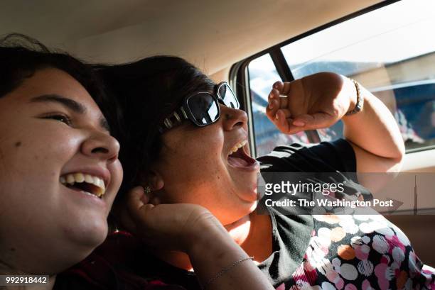 Lourdes Quintana-Salazar and her mother, Lourdes Salazar laugh in the backseat of their car as they drive to visit family in the country. MUST...