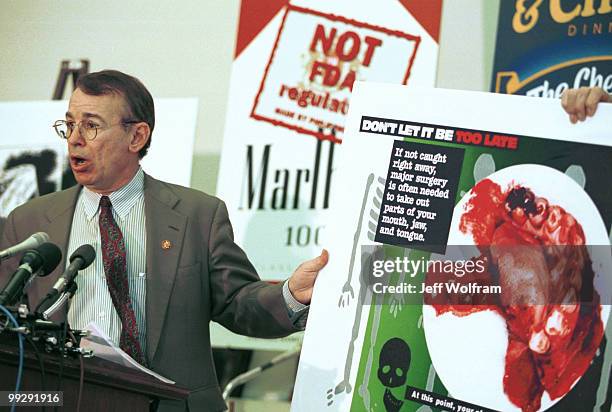 Congressman Greg Ganske displays a photo of the effects of a chewing tobacco on the mouth during a press conference unveil legislation for the FDA to...