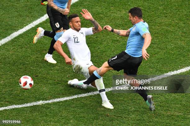 France's midfielder Corentin Tolisso vies for the ball with Uruguay's midfielder Cristian Rodriguez during the Russia 2018 World Cup quarter-final...