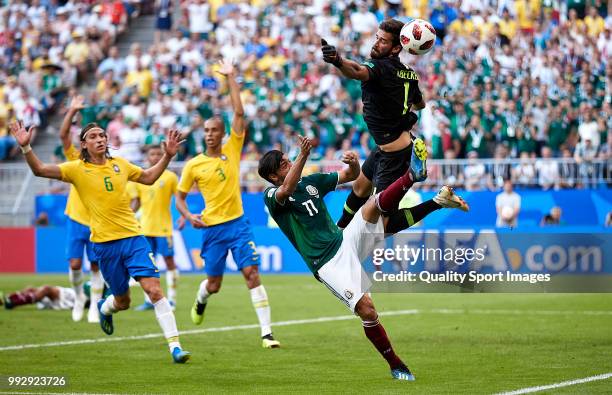 Alisson of Brazil makes a save under pressure from Carlos Vela of Mexico during the 2018 FIFA World Cup Russia Round of 16 match between Brazil and...