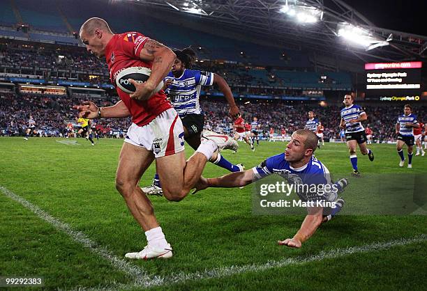 Matt Cooper of the Dragons beats the tackle of Luke Patten of the Bulldogs to score a try during the round 10 NRL match between the...