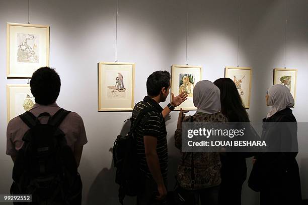 Syrians look at printed artwork of artist Salvador Dali at a gallery in Damascus on May 12, 2010. AFP PHOTO/ LOUAI BESHARA