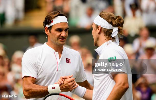Roger Federer of Switzerland shakes hands with Lukas Lacko of Slovakia after winning their second round match at the All England Lawn Tennis and...