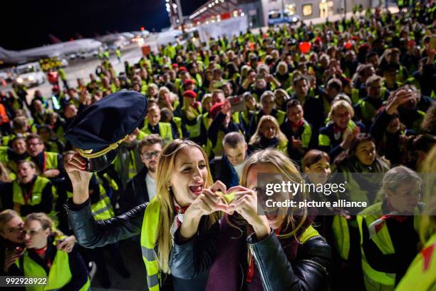 Employees of the bankrupt German airline, Air Berlin gather to welcome the company's last plane at Tegel airport in Berlin, Germany, 27 October 2017....