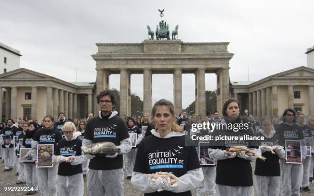 Animal rights activists from the group Animal Equality hold dead animals in their hands during a silent protest in front of the Brandenburg Gate in...