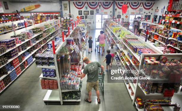 Customers fill shopping carts at Atomic Fireworks in Seabrook, NH on July 3, 2018. Massachusetts bans all recreational fireworks, but that hasnt...