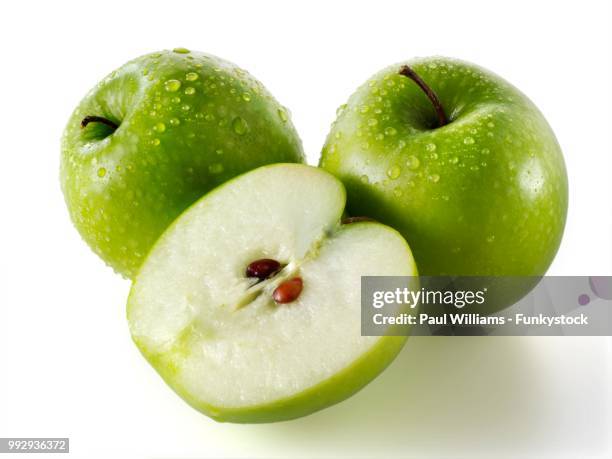 whole and cut granny smith apples - granny smith stock pictures, royalty-free photos & images