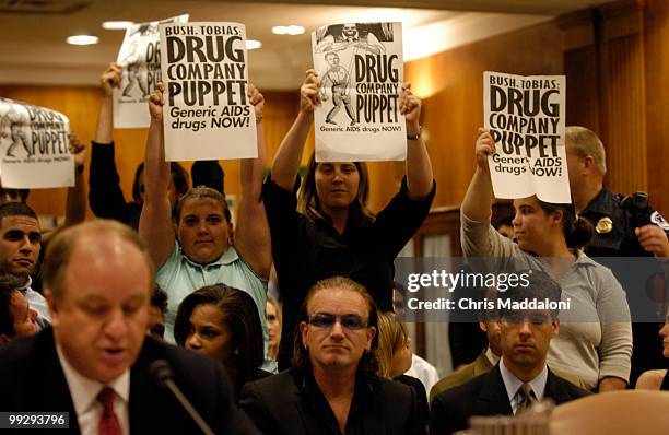 Demonstrators from HealthGap hold up signs promoting generic Aids medication during Randall Tobias, global HIV/AIDS coordinator testimony at a Senate...