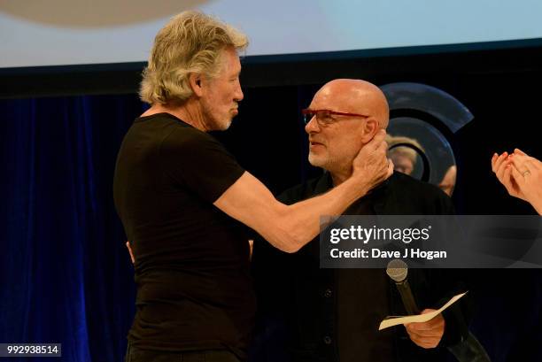 Roger Waters , winner of the O2 Silver Clef Award and presenter Brian Eno on stage during the Nordoff Robbins' O2 Silver Clef Awards ceremony at...