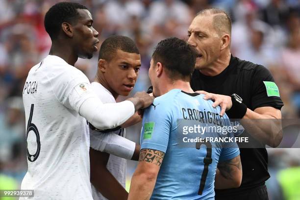 France's midfielder Paul Pogba and France's forward Kylian Mbappe argue with Uruguay's midfielder Cristian Rodriguez beside Argentininian referee...