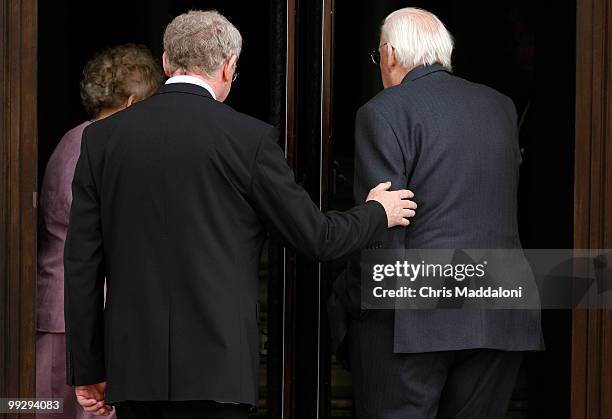 Deputy First minister Martin McGuinness, of Sinn Fein, helps First Minister Ian Paisley, of the DUP, back inside after the ceremonies to start local...