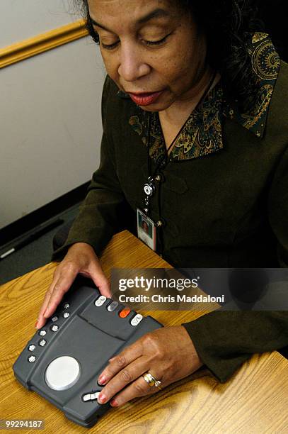 Freddie Peaco, a government infomration and voluteener specialist, who is also blind, examine a prototype design for a 'digital audio book' at the...