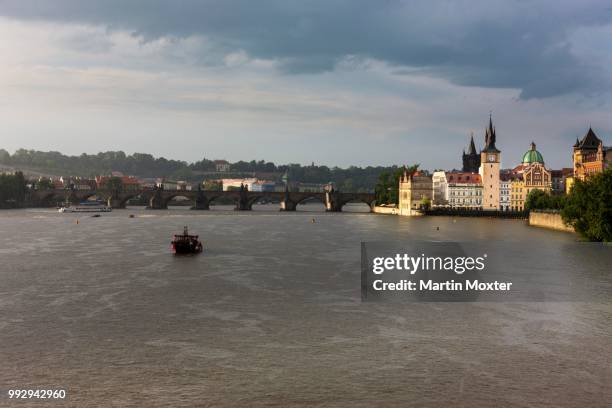 vltava river during a thunderstorm and rain, charles bridge at back, mala strana, prague, czech republic - mala strana stock-fotos und bilder