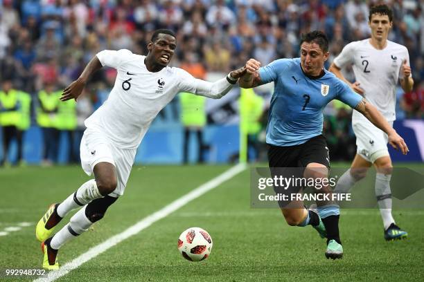 France's midfielder Paul Pogba vies with Uruguay's midfielder Cristian Rodriguez during the Russia 2018 World Cup quarter-final football match...
