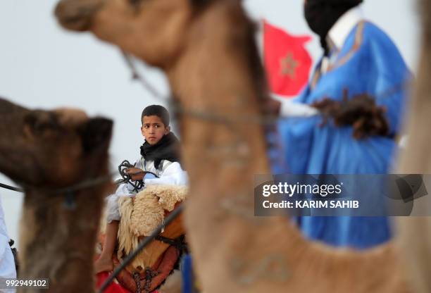 Youth rides a camel during the opening ceremony of the 14th Tan-Tan Moussem Berber festival in the western Moroccan desert town of Tan-Tan on July 6,...