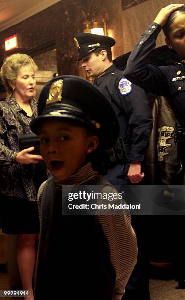 Tenia Jordan tries on her faither's hat before the graduation ceremony of the Capitol Police class.