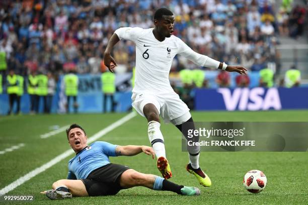 France's midfielder Paul Pogba vies with Uruguay's midfielder Cristian Rodriguez during the Russia 2018 World Cup quarter-final football match...