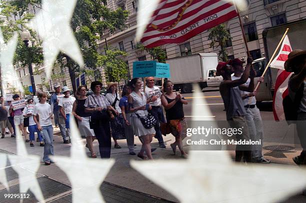 Demonstrators rally from Freedom Plaza for DC voting rights, reflected in a window with the US flag. During the annual session of the Organization...