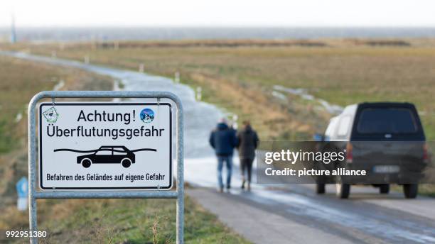 Sign reading 'Achtung! Ueberflutungsgefahr' (lit. 'Attention! Danger of floods' can be seen at the camping site at the city beach Sehestedt, where...