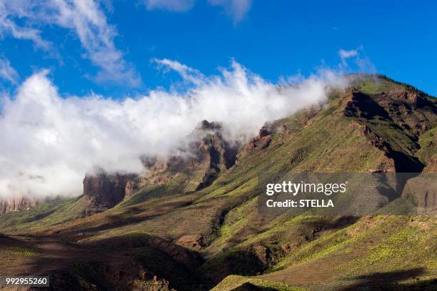 wispy clouds over a mountain ridge, santa lucia de tirajana, gran canaria, canary islands, spain - sankta lucia 2015 stock pictures, royalty-free photos & images