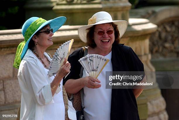 Carlotta Litten, and Kathy Metcalf, tourists visiting the Capitol from the midwest, cool off in the heat with fans on the West Front.