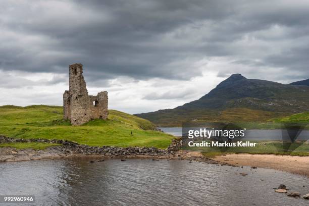 ruins of ardvreck castle on a peninsula in the lake of loch assynt, in front of the 764m mountain of spidean coinich, sutherland, schottisches hochland, scotland, united kingdom - loch assynt stockfoto's en -beelden