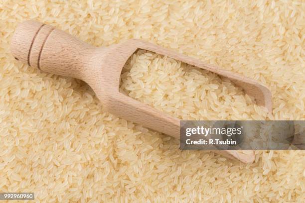 spoon of rice on puffed rice cereal background close up - puffed rice stock pictures, royalty-free photos & images