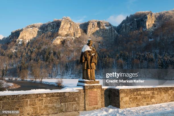 hausener bridge with the statue of st. nepomuk in front of the hausener zinnen rocks in the evening light, hausen im tal, donautal, baden-wuerttemberg, germany - donautal stock-fotos und bilder