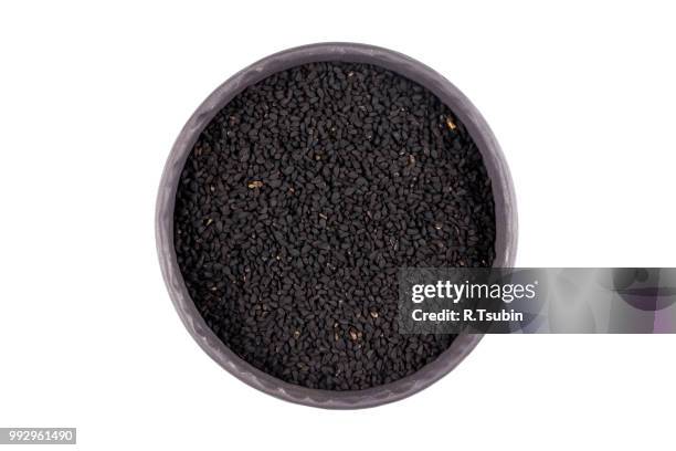 sesame black seeds in stone bowl isolated on white background - makrobiotik stock-fotos und bilder