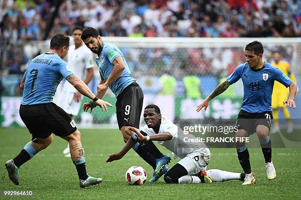 France's midfielder Paul Pogba falls on the ground beside Uruguay's forward Luis Suarez during the Russia 2018 World Cup quarter-final football match...